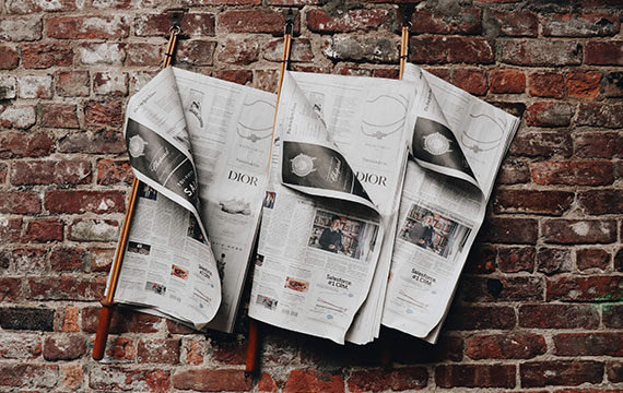 Zeitungen hängen an einer Mauer
